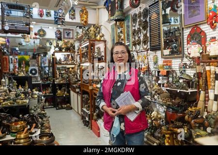 Hongkong - 2022. Dezember Porträt einer Frau, die ein Antiquitätengeschäft in Stanely Market betreibt Stockfoto