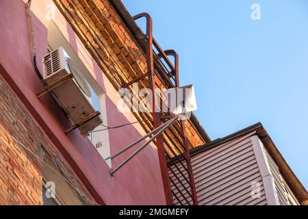 Starlink Satellitenschüssel, eine von SpaceX betriebene Internetkonstellation, ist an der Wand eines Apartmentgebäudes installiert. Stockfoto