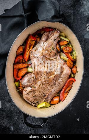 Geröstetes Lammhammel-Schulterfleisch in einer Backform mit Gemüse. Schwarzer Hintergrund. Draufsicht Stockfoto