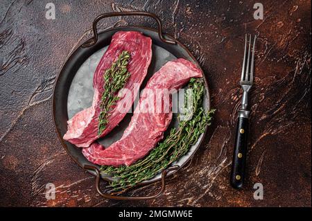 Rohes Bavette- oder Sirloin-Lappen-Rindersteak mit Thymian. Dunkler Hintergrund. Draufsicht Stockfoto