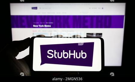 Person, die ein Smartphone mit dem Logo des US-amerikanischen Ticketunternehmens StubHub auf dem Bildschirm vor der Website hält. Konzentrieren Sie sich auf das Display des Telefons. Stockfoto