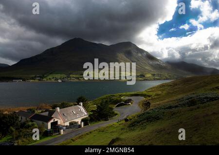 Mit Blick über Loch Sligachan zum Glamaig Teil von Red Collins auf der Isle of Skye mit kleinen Häusern/Haus, wenn das Wetter überrollt Stockfoto