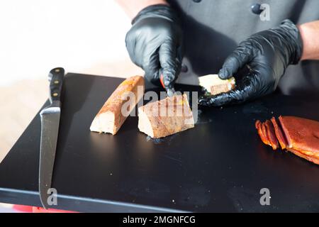 Der Kellner im Restaurant schneidet auf einer Eventparty Fleisch Stockfoto