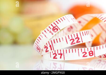 Weight Watcher - Maßband mit verschiedenen Früchten im Hintergrund Stockfoto