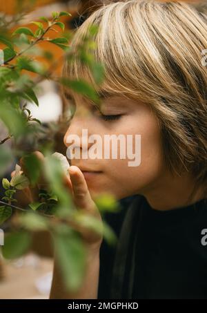 Ein Junge, der Blumen riecht Stockfoto