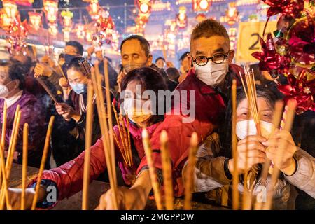 Gläubige verbrennen ihre ersten Joss-Sticks am Weihrauch-Brenner, im Wong Tai Sin Tempel in Hongkong. Die Menschen strömten zum Tempel der Wong Tai Sin, um zum ersten Mal seit drei Jahren seit der COVID-Pandemie zu beten, als sie sich versammelten, um ihre ersten Joss-Stäbe zu verbrennen, um das Mondneujahr und das Jahr des Hasen im chinesischen Tierkreislauf zu feiern. Stockfoto