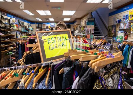 Festival-Kleidung oder -Ausrüstung zum Verkauf in einem Wohltätigkeitsladen in Bristol, Großbritannien Stockfoto