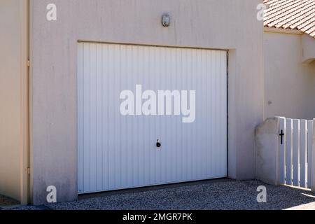 Schwenkbares Garagentor aus Metall, Zugang zum Haus für ein Auto mit weißer Tür Stockfoto