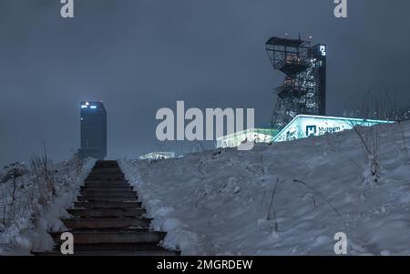 Kattowitz, Schlesien, Polen - 20. 2023. Januar: Nachtansicht im Schlesischen Museum. Der beleuchtete Grubenschachtturm der ehemaligen Grube „Kattowitz“ und der moderne Platz, Stockfoto