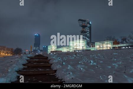 Kattowitz, Schlesien, Polen - 20. 2023. Januar: Nachtansicht im Schlesischen Museum. Der beleuchtete Grubenschachtturm der ehemaligen Grube „Kattowitz“ und der moderne Platz, Stockfoto