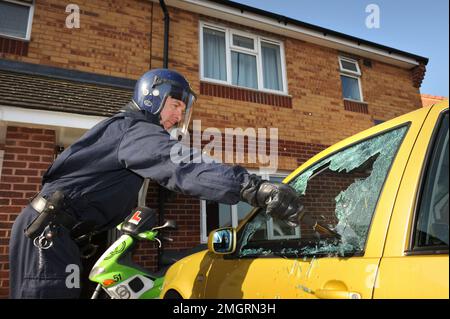 Polizeibeamte des Einsatzteams brechen in ein verdächtiges Auto in Gloucester ein, wo eine von mehreren Morgenangriffen im Rahmen von Operation Z stattfand Stockfoto