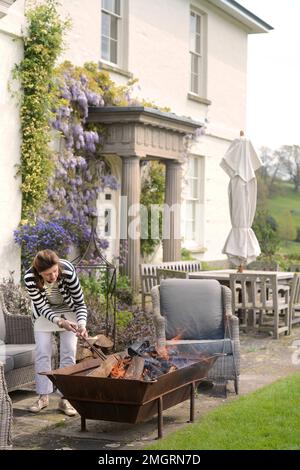 Landhaus mit Feuerstelle auf der Terrasse. Stockfoto