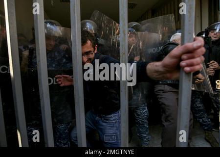 Beirut, Libanon. 26. Januar 2023. Die libanesische Aufruhr-Polizei stößt am Eingang des Justizministeriums in Beirut auf einen Aktivisten, Angehörige und Familien der Opfer der Explosion im Hafen von Beirut von 2020, um gegen eine Entscheidung des libanesischen Oberstaatsanwalts zu protestieren, der den Richter angeklagt hat, der die Untersuchung der Explosion leitet Das tötete mehr als 200 Menschen und ordnete die Freilassung von Verdächtigen in Haft an. Kredit: Marwan Naamani/dpa/Alamy Live News Stockfoto