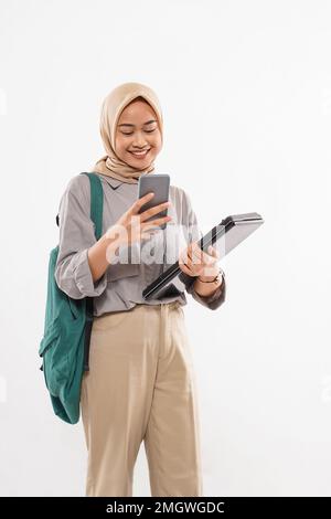 Eine Schülerin mit Hijab und der grünen Tasche an der Schulter Stockfoto