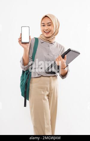 Eine schöne Schülerin mit Hidschab, die das Telefon zeigt Stockfoto