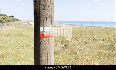 Farbige Markierungen für Wander- und Wanderwege an der natürlichen Küste des Meeres Stockfoto