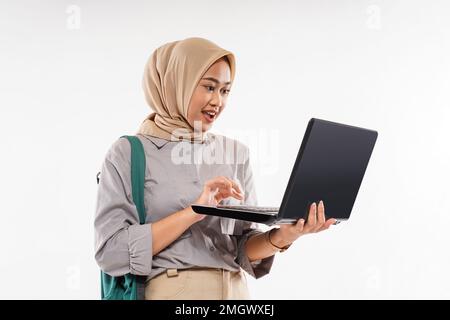 Eine Studentin mit Hijab schockiert, als sie den Laptop öffnete Stockfoto