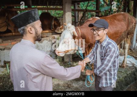 Der männliche Bauer steht und schüttelt mit dem moslem Stockfoto