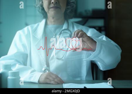 Kardiologe mit rotem Herz in Privatklinik. Medizintechnik Diagnostik von Herz-Konzept Stockfoto