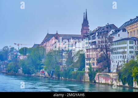 Blick auf das Rheinufer mit historischen Wohnhäusern und Türmen des Basler Münsters im Hintergrund, Schweiz Stockfoto