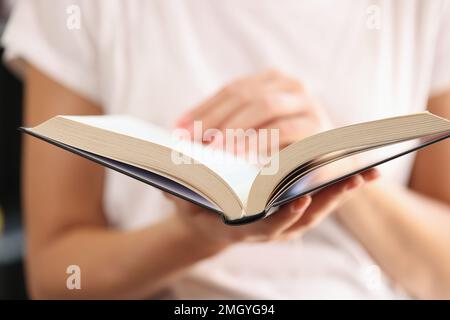 Ein offenes Buch in den Händen einer Frau, Nahaufnahme, geringe Tiefenschärfe. Stockfoto