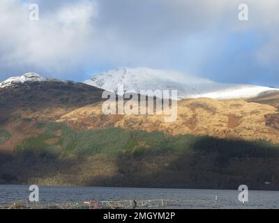 Schottlands Berge im Wintersonnenlicht: Blick nach Osten von Inverbeg über Loch Lomond in Richtung des schneebedeckten Ben Lomond. Stockfoto