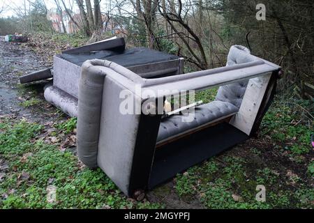 Egham, Surrey, Großbritannien. 26. Janaury, 2023. Ein Sofa, das illegal am Straßenrand in Egham, Surrey, geflogen ist. Flugtipp ist eine Straftat, die zu einer Strafverfolgung mit Geldstrafen oder Freiheitsstrafen führen kann. Illegal verschütteter Hausmüll zerstört viele Städte in ganz England. Kredit: Maureen McLean/Alamy Live News Stockfoto