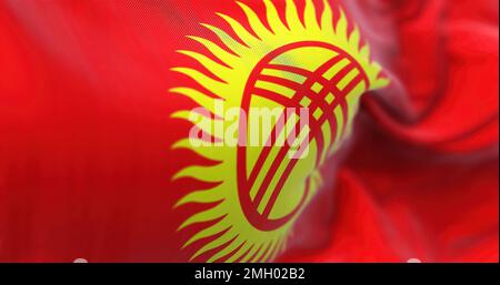 Perspektivischer Blick auf die Nationalflagge Kirgisistans, die im Wind flattert. Rote Flagge mit stilisierter Sonne in der Mitte. Flatternder Stoff. Selektiver FOC Stockfoto