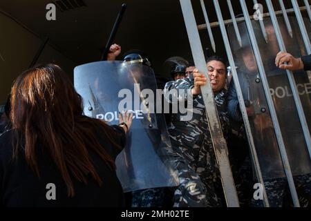 Beirut, Libanon. 26. Januar 2023. Ein Mitglied der inneren Sicherheitskräfte tritt einen Demonstranten, während ein anderer seinen Stab schwingt, nachdem die Demonstranten das Tor während einer Demonstration im Justizpalast in Beirut, Libanon, am 26. Januar 2023 aufbrachen. Die Demonstration wurde von Familienmitgliedern von Opfern organisiert, die beim Beirut Blast getötet wurden. Die Demonstranten, wütend über Richter Ghassan Oueidat, die alle Gefangenen im Zusammenhang mit der Explosion gestern freigelassen haben, sind durch ein Tor eingedrungen. Ein paar Demonstranten wurden verletzt, aber sie schafften es, ein paar Sicherheitsleute auf die Straße zu ziehen und sie anzugreifen. Sicherheitsantwort von SP Stockfoto