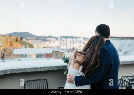 Verliebtes Ehepaar, das an seinem Hochzeitstag Händchen hält Stockfoto