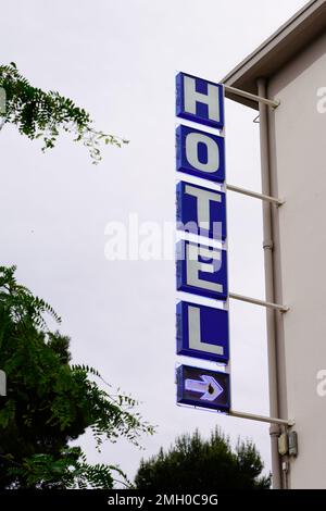 Hotelschild mit blauem Pfeil in der Wandfassade der französischen Touristenstadt Stockfoto