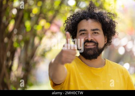 Porträt eines Mexikaners, der mit Afro und Bart lächelt Stockfoto