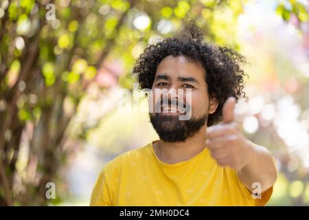 Porträt eines Mexikaners, der mit Afro und Bart lächelt Stockfoto
