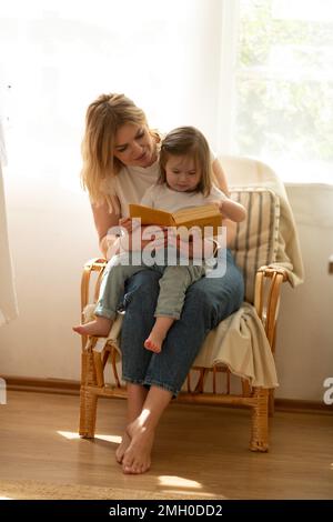 Mom liest ihrer kleinen Tochter ein Buch vor Stockfoto