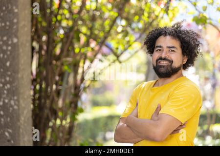 Porträt eines Mexikaners, der mit Afro lächelt, die Arme kreuzten den Kopierraum Stockfoto