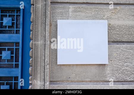 Leeres weißes Schild am Eingangsschild an strukturiertem Wandmodell Stockfoto