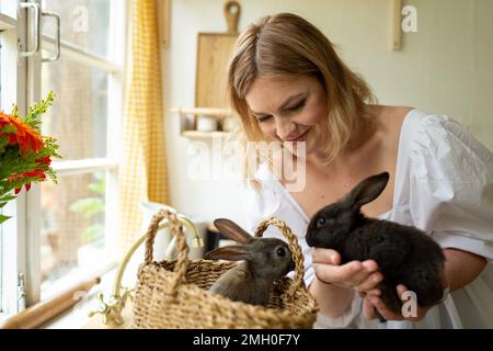 Eine Frau hält Kaninchen, lächelt, Osterkonzert Stockfoto