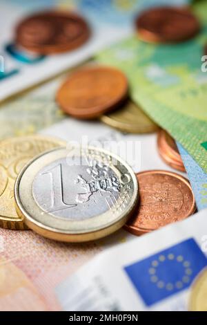 Euro-Scheine und -Münzen, die sich auf einem Tisch stapeln. Stockfoto