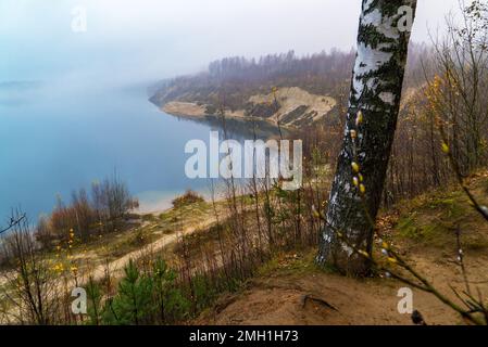 Nebel fällt auf dem See an der steilen Küste Stockfoto