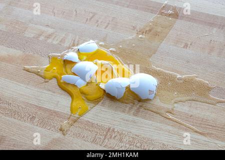 Horizontaler Schuss eines zerbrochenen weißen Eies auf den Boden. Stockfoto