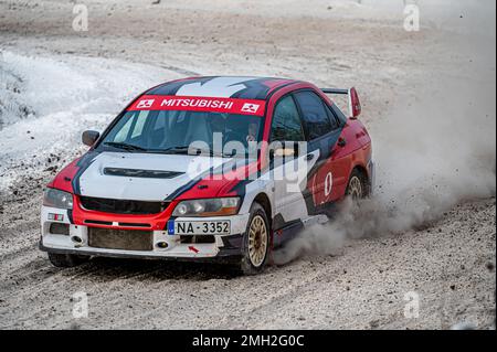 Tukums, Lettland - Januar. 7. 2023: Kinder üben mit dem Straßensportwagen Mitsubishi Lancer Evo sicheres Fahren auf der Winterstrecke Stockfoto