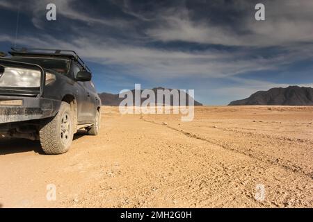 Berglandschaft mit Geländefahrzeug. Panorama einer Wüste in Afghanistan mit Bergen im Hintergrund Stockfoto