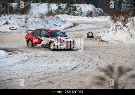 Tukums, Lettland - Januar. 7. 2023: Kinder üben mit dem Straßensportwagen Mitsubishi Lancer Evo sicheres Fahren auf der Winterstrecke Stockfoto