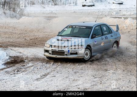 Tukums, Lettland - Januar. 7. 2023: Kinder üben mit dem Straßensportwagen Mitsubishi Lancer Evo sicheres Fahren auf der Winterstrecke Stockfoto