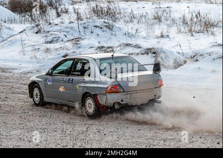 Tukums, Lettland - Januar. 7. 2023: Kinder üben mit dem Straßensportwagen Mitsubishi Lancer Evo sicheres Fahren auf der Winterstrecke Stockfoto