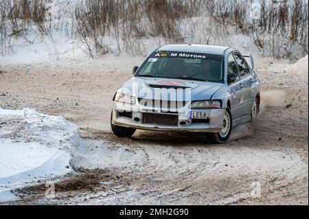 Tukums, Lettland - Januar. 7. 2023: Kinder üben mit dem Straßensportwagen Mitsubishi Lancer Evo sicheres Fahren auf der Winterstrecke Stockfoto