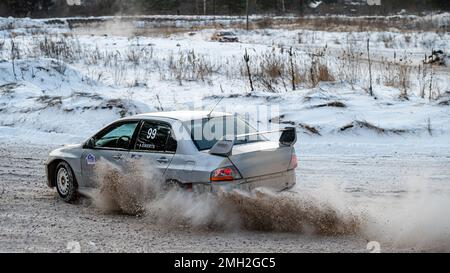 Tukums, Lettland - Januar. 7. 2023: Kinder üben mit dem Straßensportwagen Mitsubishi Lancer Evo sicheres Fahren auf der Winterstrecke Stockfoto