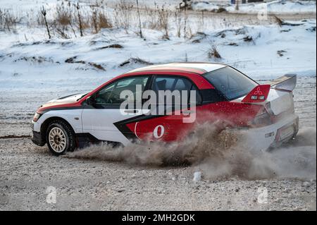 Tukums, Lettland - Januar. 7. 2023: Kinder üben mit dem Straßensportwagen Mitsubishi Lancer Evo sicheres Fahren auf der Winterstrecke Stockfoto