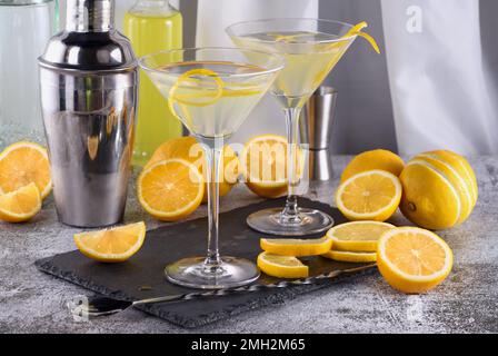 Lemon Drop martini mit Schale bietet eine raffinierte Note zu einem Cocktail. Dieser leichte und herzhafte Favorit kombiniert Wodka, Orangenlikör und frische Zitrone ju Stockfoto