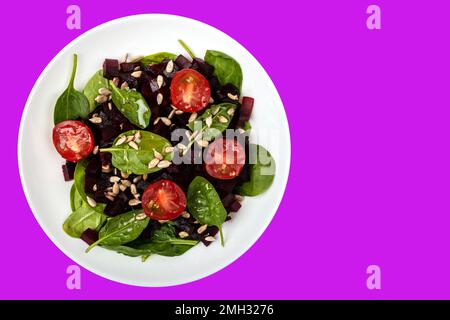 Salat mit Rote-Bete-Spinat Kirschtomaten und Samen gesunde vegetarische Speisen auf isoliertem Hintergrund Stockfoto